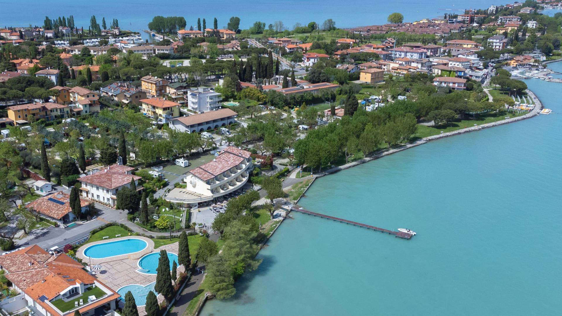 Vista aerea di una cittadina costiera con piscina e lago.