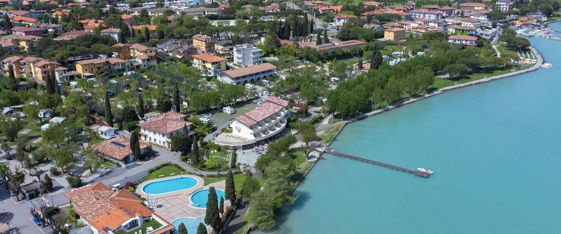 Vue aérienne d'un complexe touristique avec piscine et accès au lac.